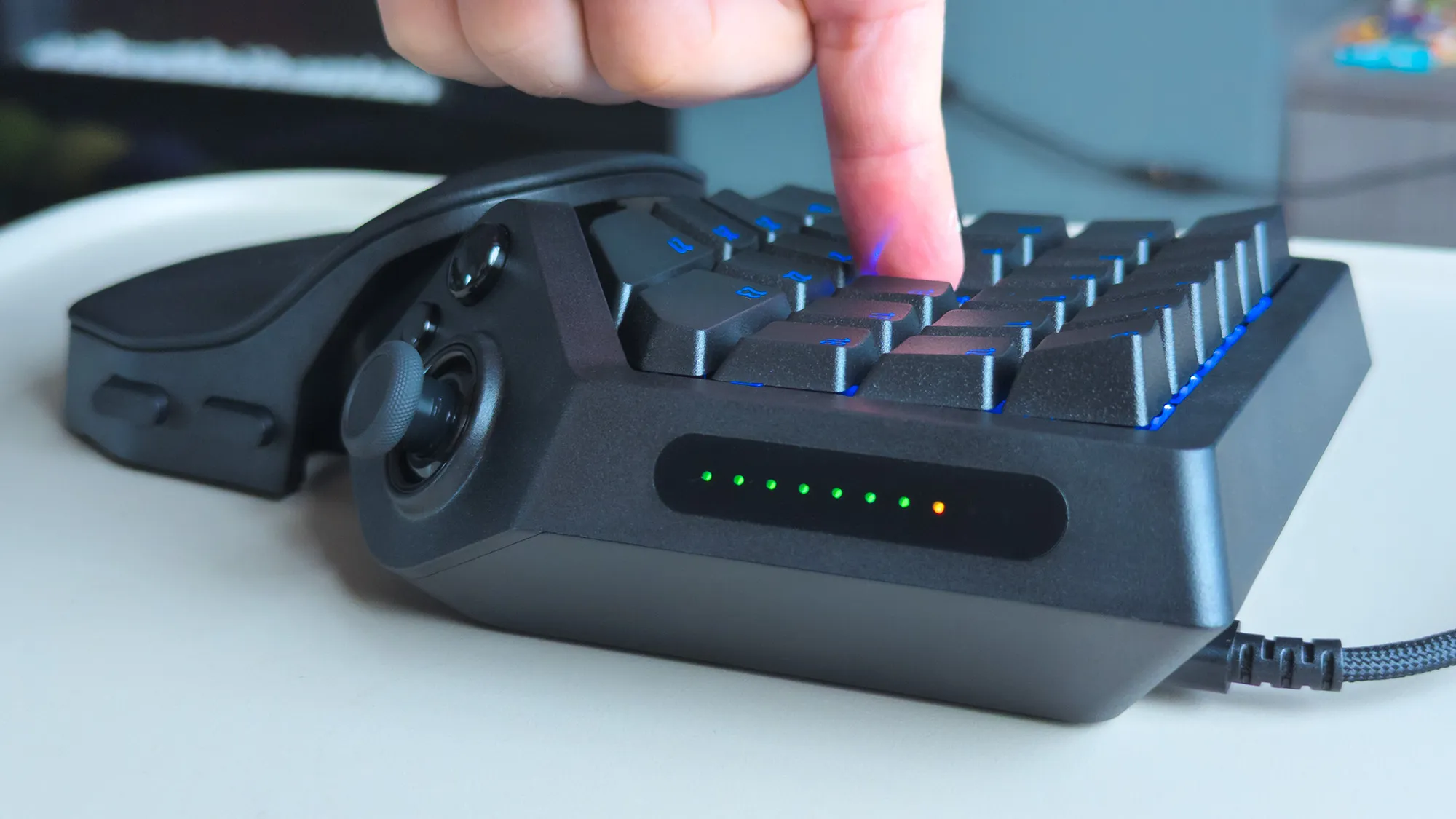 Razer Tartarus V2 Pro with finger pressing a key, highlight pressure with green and orange LEDs